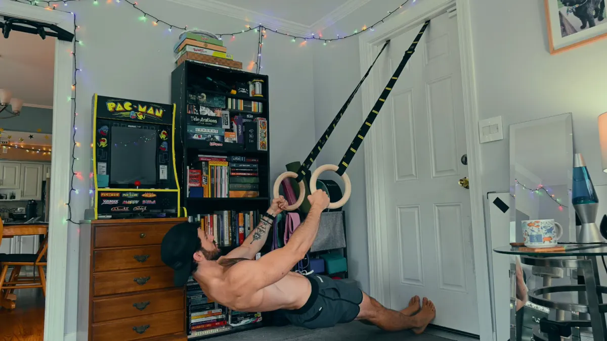 Bodyweight row on gymnastics rings anchored over a door